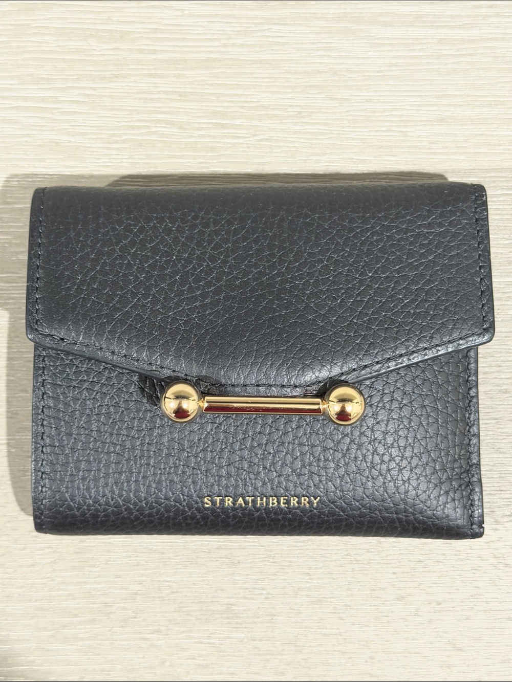 Strathberry Black Pebbled Leather Compact Wallet with Gold Bar